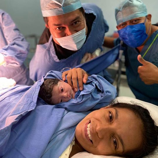 Médicos de Fertilt revisando a paciente y recién nacido después del parto.